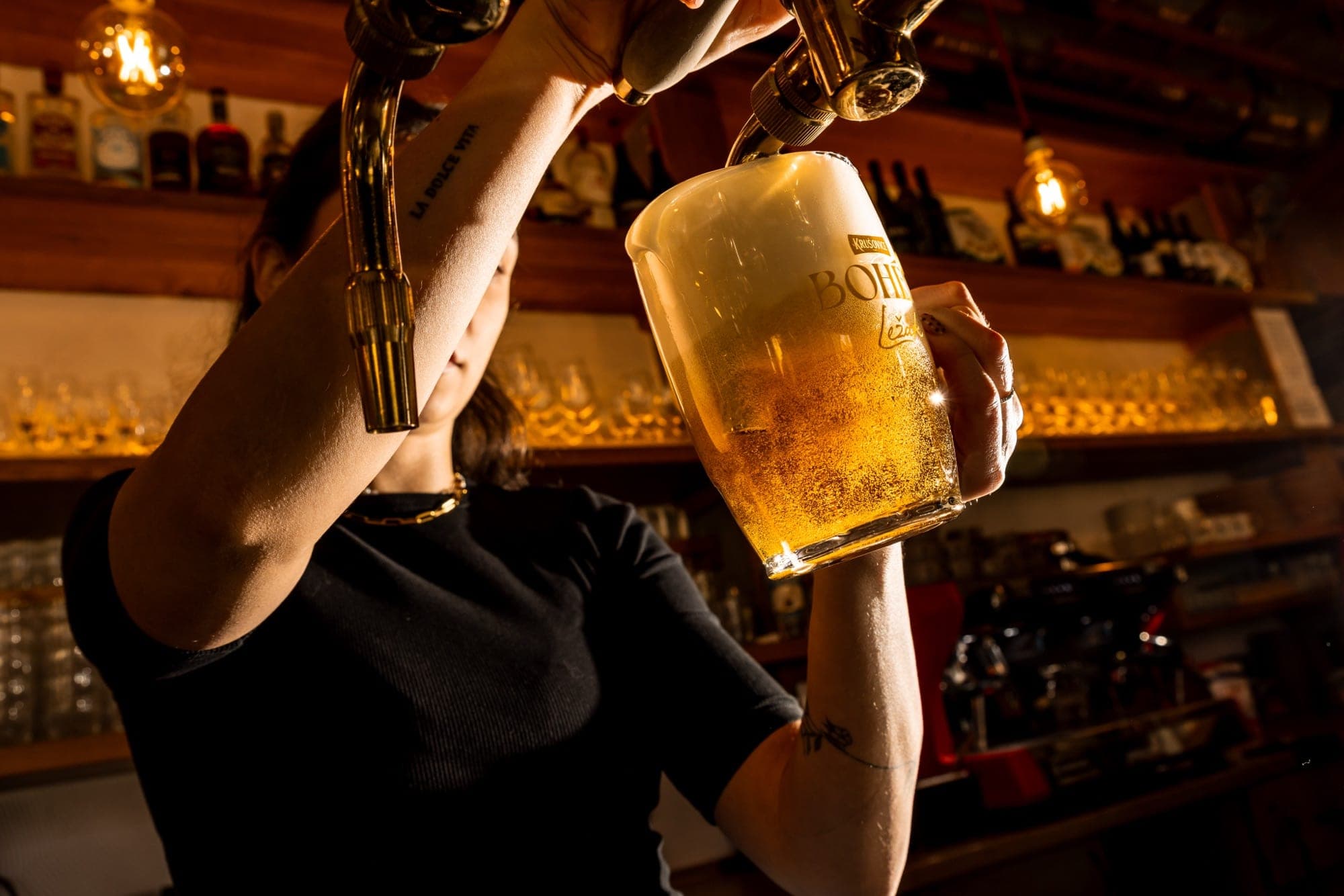 Hlavní sál s dřevěnými stoly a velkými okny